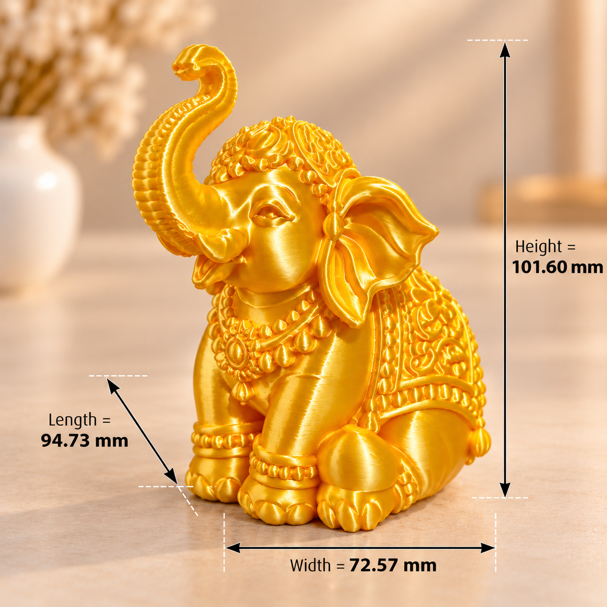 Golden elephant 3D printed miniature in silk gold PLA finish on a white surface, side view showing detailed trunk-up pose