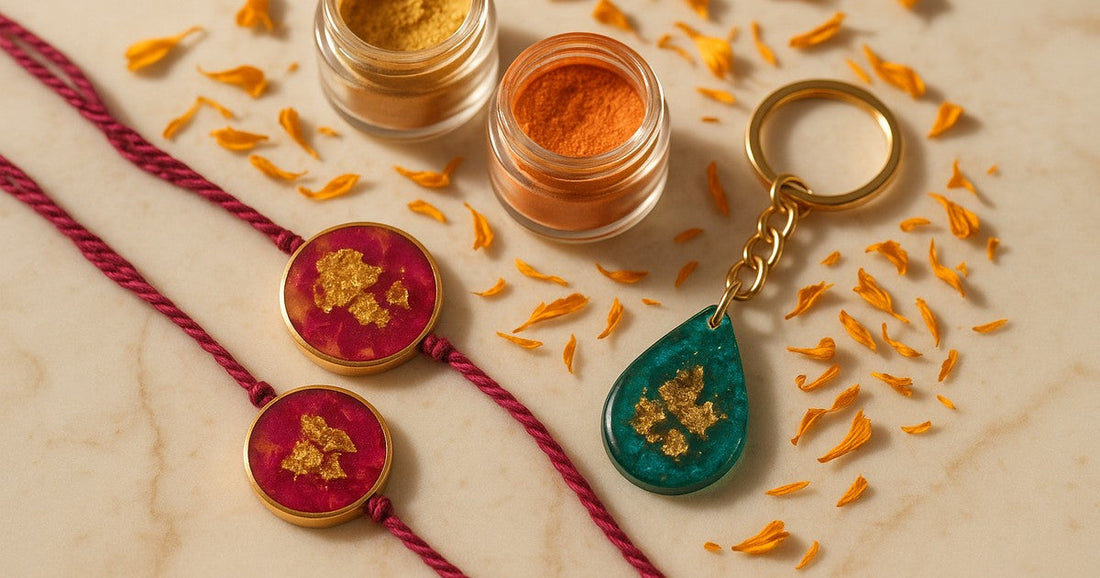 Handmade Raksha Bandhan resin gifts in antique gold, magenta, and peacock teal mica powder colours on a marble surface with marigold petals