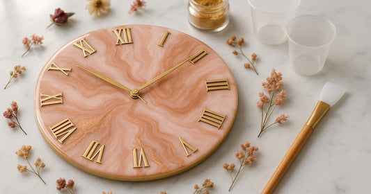 Finished 12-inch resin clock face with blush pink and rose gold swirl design, gold Roman numerals, and gold clock hands on a marble surface