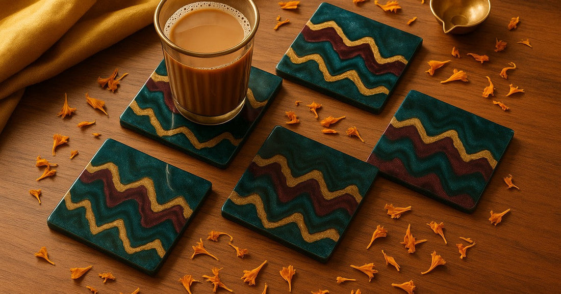 Handmade square zigzag resin coaster set in teal, burgundy, and gold on a teak wood surface with chai glass and Indian festive décor