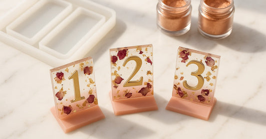 Handmade resin table numbers for wedding in blush pink and gold with dried flowers, cast using a silicone tray mould