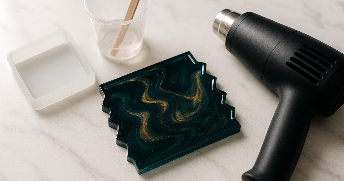 Crystal-clear square zigzag epoxy resin coaster demoulded from a silicone mould with no air pockets, photographed on white marble with craft tools